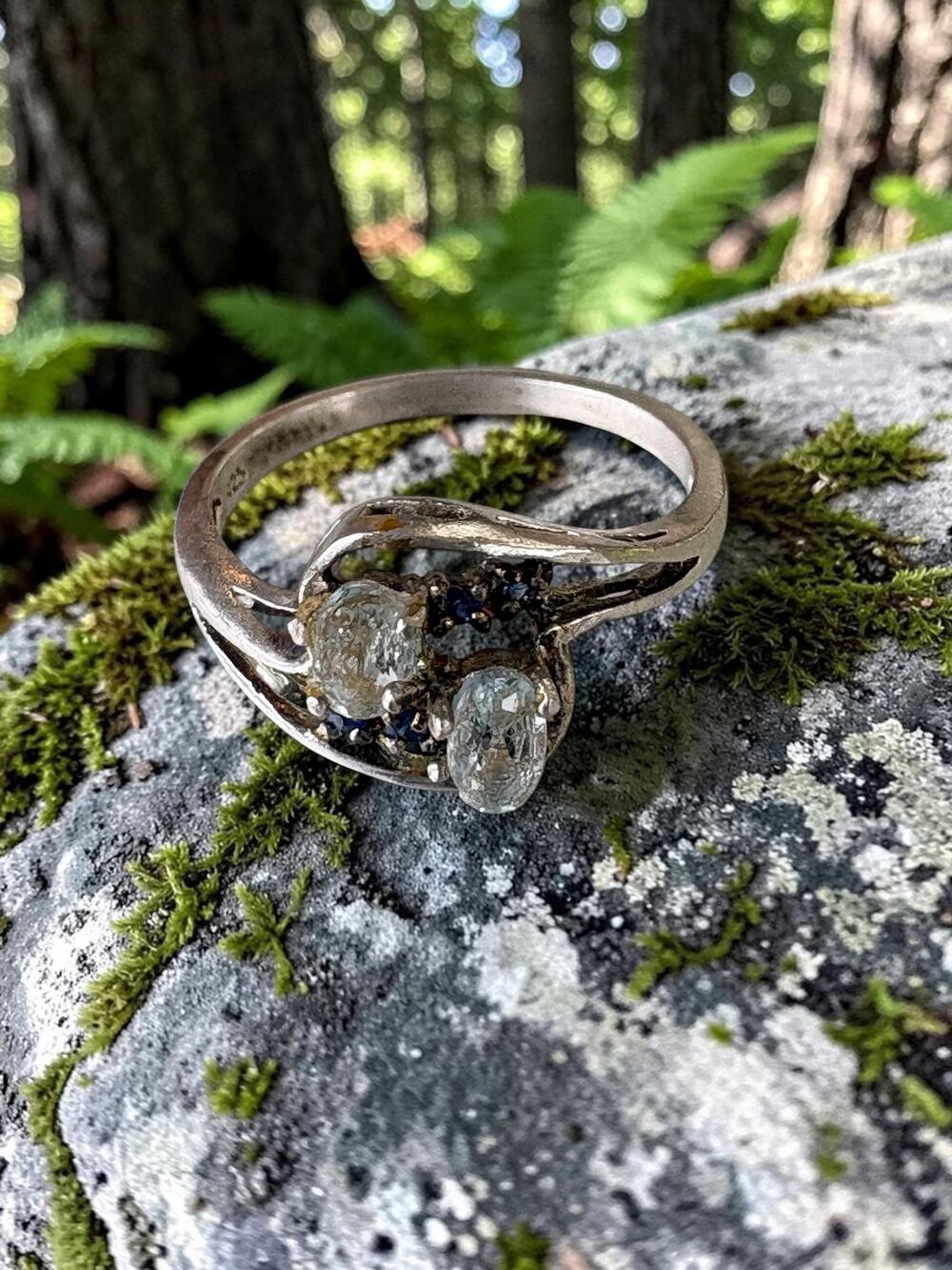 Vintage sterling silver clear stone sculptural bypass ring with deep blue accent